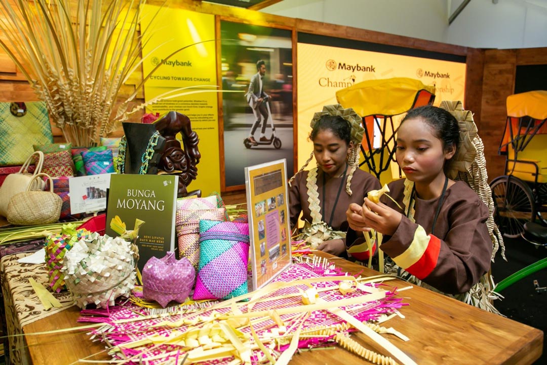 Two Maybank Women Eco-Weavers from Mah Meri Tribe are demonstrating their weaving skills, celebrating craftsmanship and sustainability